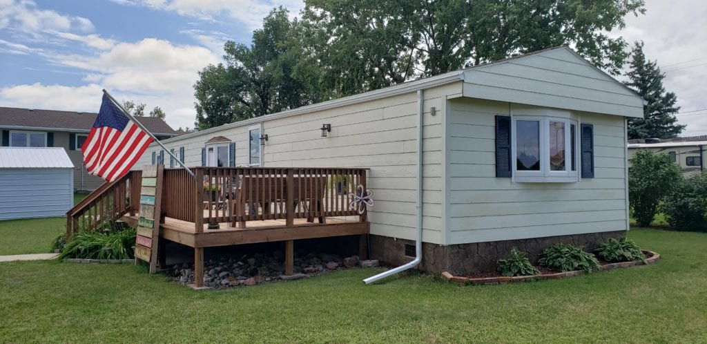 mobile home with white siding and a deck